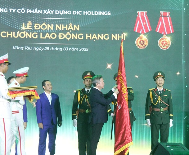 Ông Đặng Minh Thông, Ủy viên Ban Thường vụ Tỉnh ủy, Phó Chủ tịch UBND tỉnh Bà Rịa – Vũng Tàu gắn Huân chương lên lá cờ truyền thống